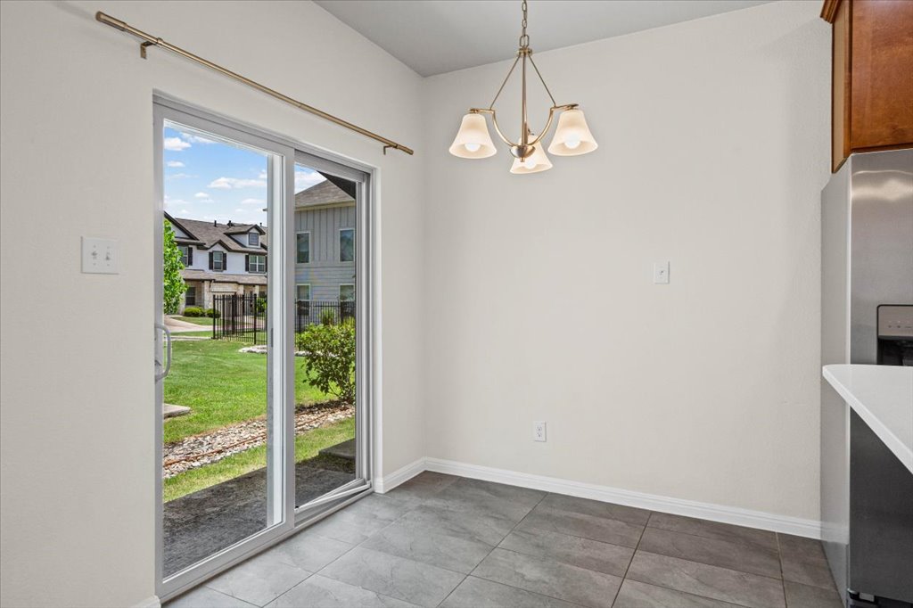 1502 Airedale Road, Unit 2502 Austin, TX 78748 - Photo 11 of 28 Sliding glass doors open to a refreshing green yard, connecting indoor comfort with outdoor tranquility.