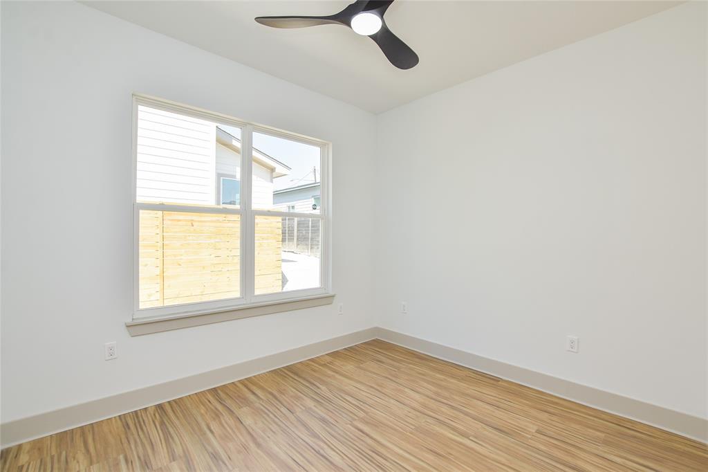 7103 Bennett Avenue, Unit 2 Austin, TX 78752 - Photo 12 of 19 an empty room with wooden floor fan and windows