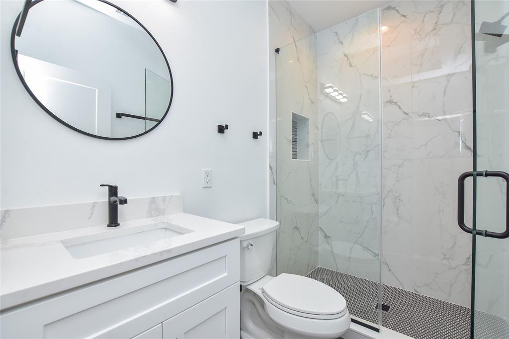 7103 Bennett Avenue, Unit 2 Austin, TX 78752 - Photo 13 of 19 a bathroom with a sink a toilet and a mirror