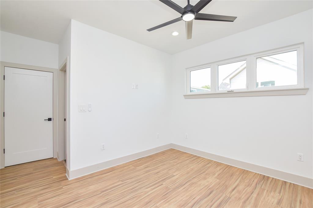 7103 Bennett Avenue, Unit 2 Austin, TX 78752 - Photo 16 of 19 an empty room with wooden floor fan and windows