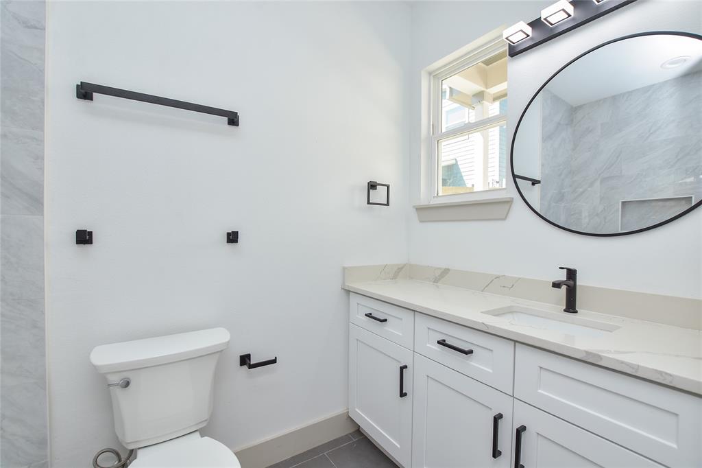 7103 Bennett Avenue, Unit 2 Austin, TX 78752 - Photo 10 of 19 a bathroom with a toilet sink vanity and mirror