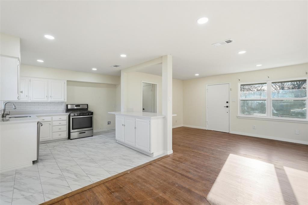 10833 Ruth Ann Drive Dallas, TX 75228 - Photo 4 of 17 a large kitchen with stainless steel appliances kitchen island a large counter top and a stove top oven