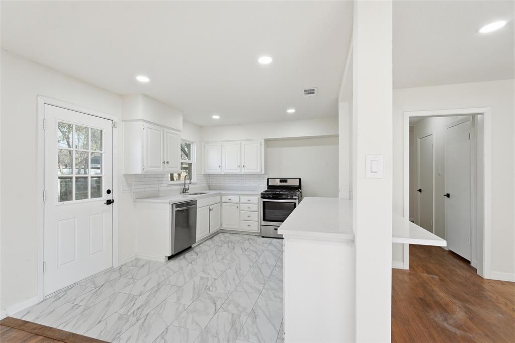 10833 Ruth Ann Drive Dallas, TX 75228 - Photo 5 of 17 a kitchen with white cabinets and appliances