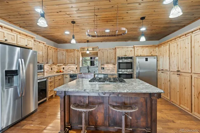 a kitchen with stainless steel appliances granite countertop a sink refrigerator and microwave
