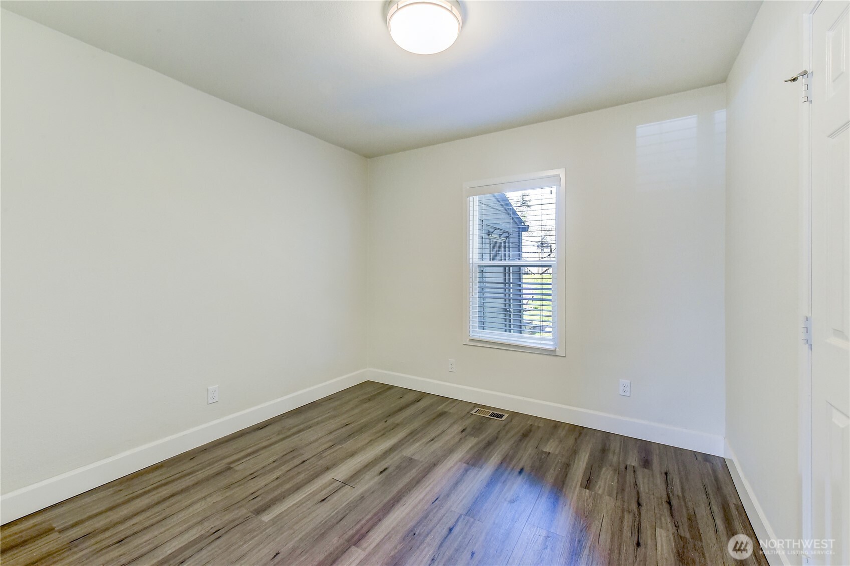 1048 South Director Street Seattle, WA 98108 - Photo 11 of 20 an empty room with wooden floor and windows