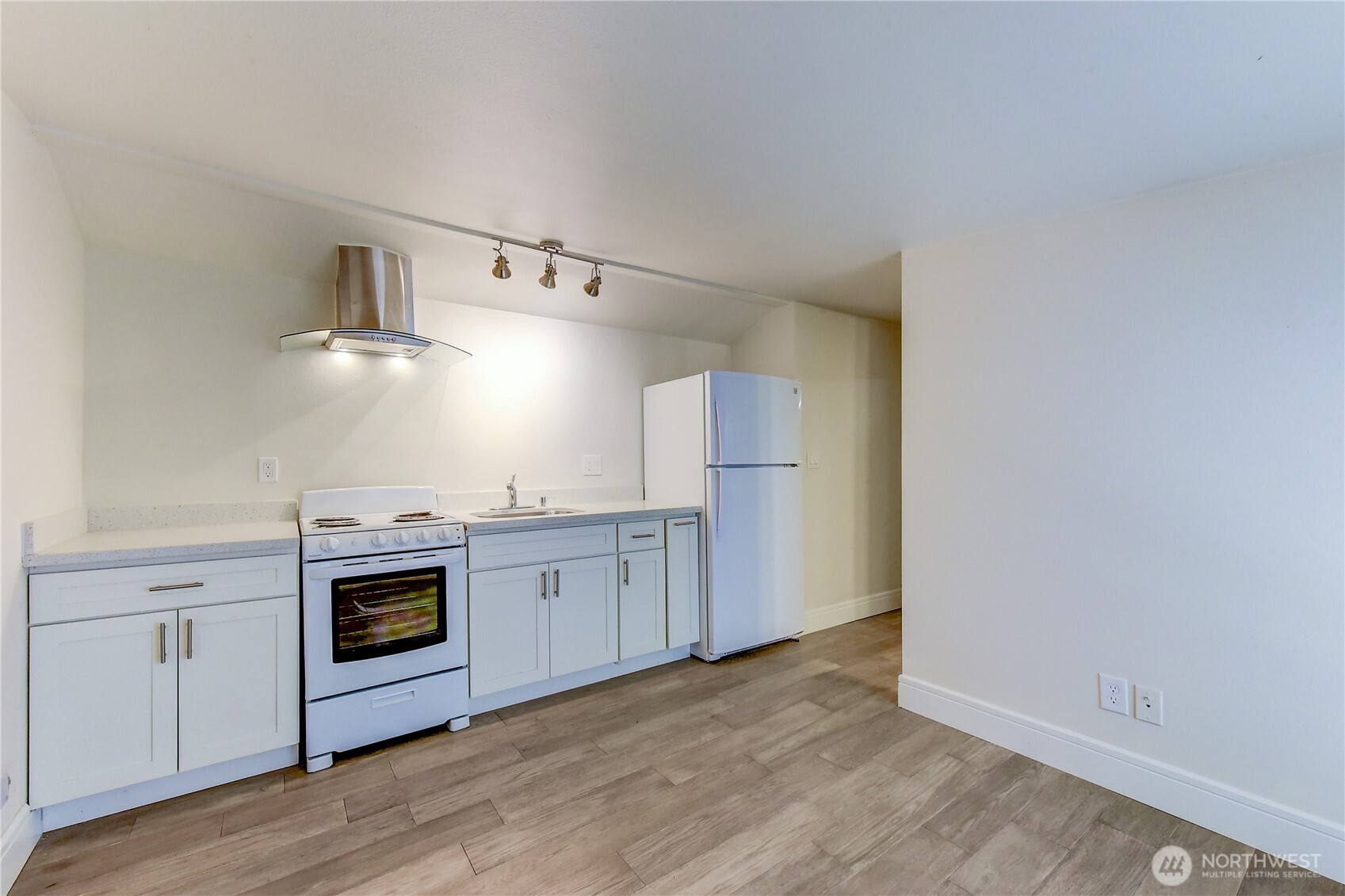 1048 South Director Street Seattle, WA 98108 - Photo 15 of 20 a kitchen with cabinets wooden floor and stainless steel appliances