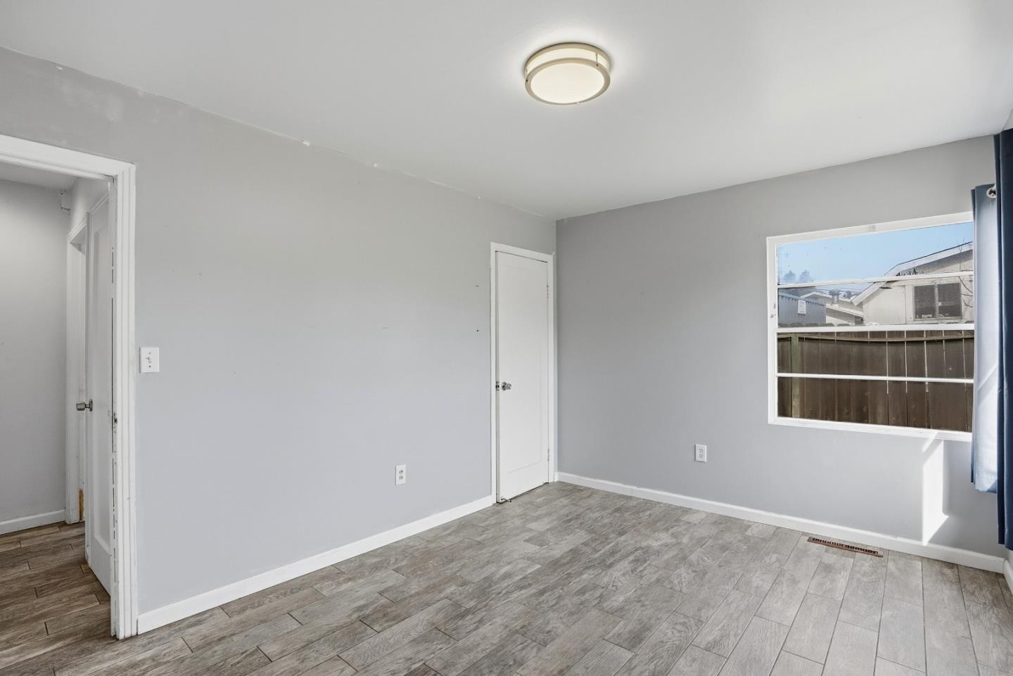 17918 Pesante Road Prunedale, CA 93907 - Photo 24 of 35 an empty room with wooden floor and windows