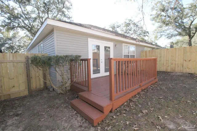 a view of a small house with wooden fence