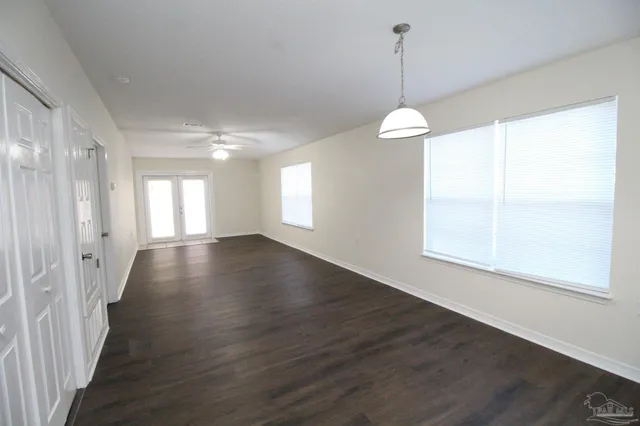 a view of a room with wooden floor and windows