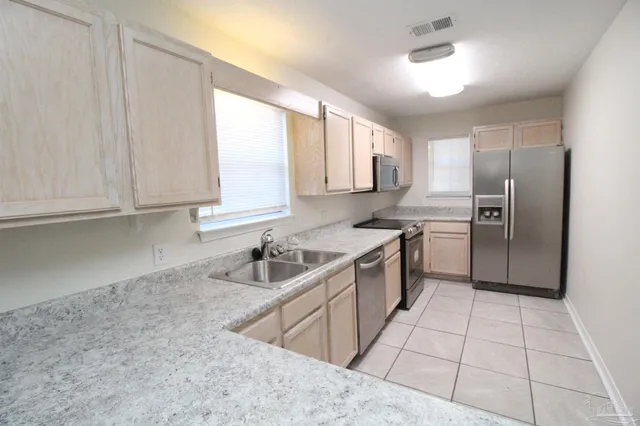 a kitchen with a sink a refrigerator and cabinets