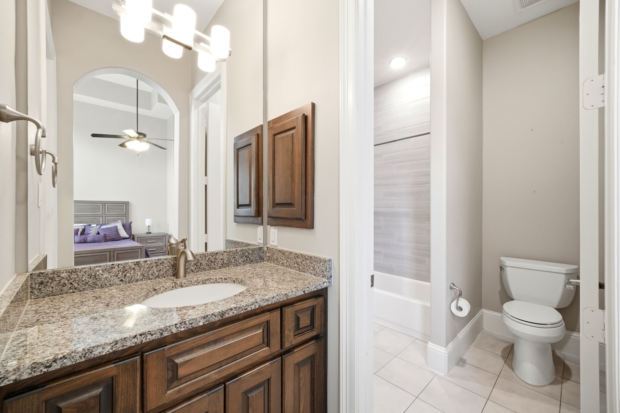 5815 Stratton Woods Drive Spring, TX 77389 - Photo 38 of 45 a bathroom with a granite countertop sink a toilet and a mirror