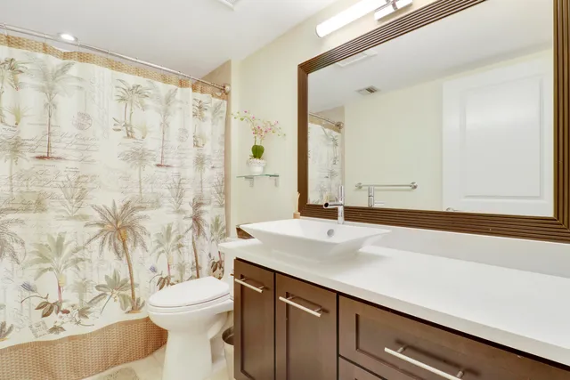a bathroom with a sink a toilet and shower curtain