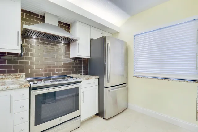 a kitchen with a stove top oven and refrigerator