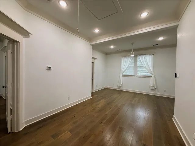 a view of a livingroom with wooden floor and a bathroom