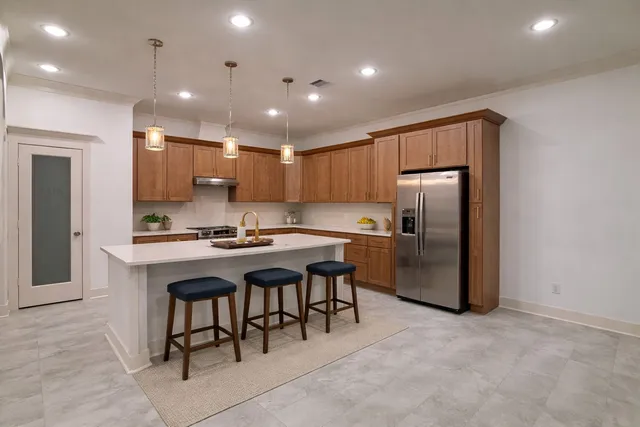 a large kitchen with a large counter top stainless steel appliances and cabinets