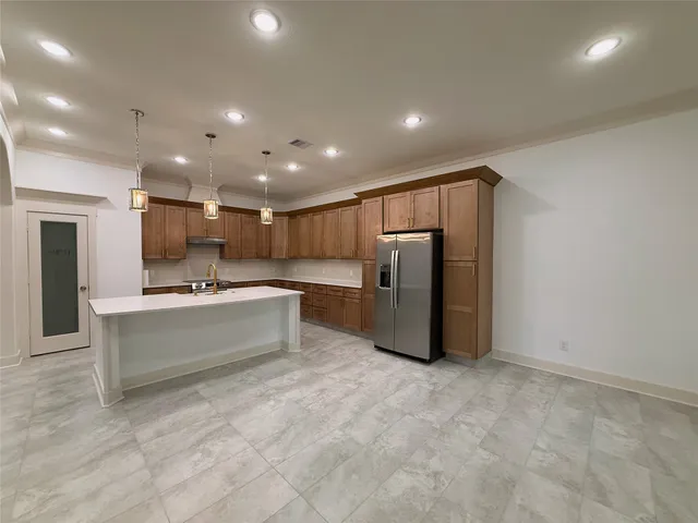 a kitchen with stainless steel appliances kitchen island a refrigerator sink and cabinets