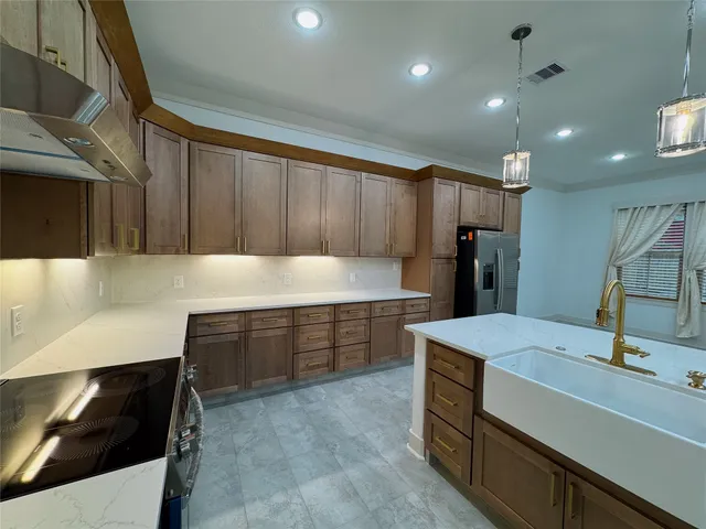 a kitchen with a sink a refrigerator and a stove