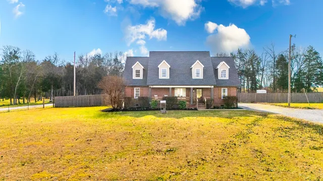 a view of a house with a swimming pool and a yard with a fountain