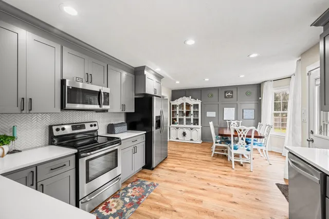 a living room with furniture a rug potted plant and a window