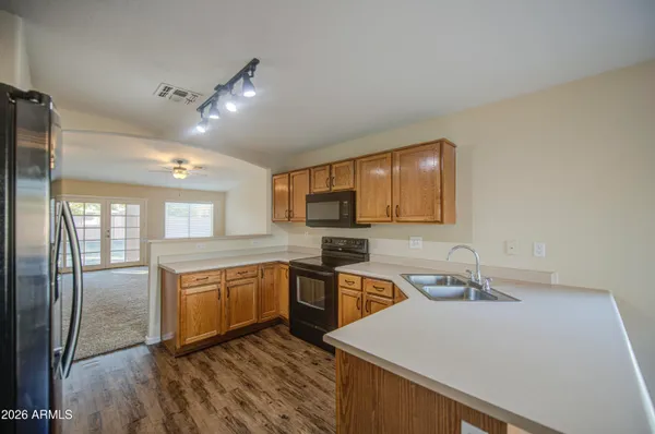 a view of an empty room with a chandelier fan