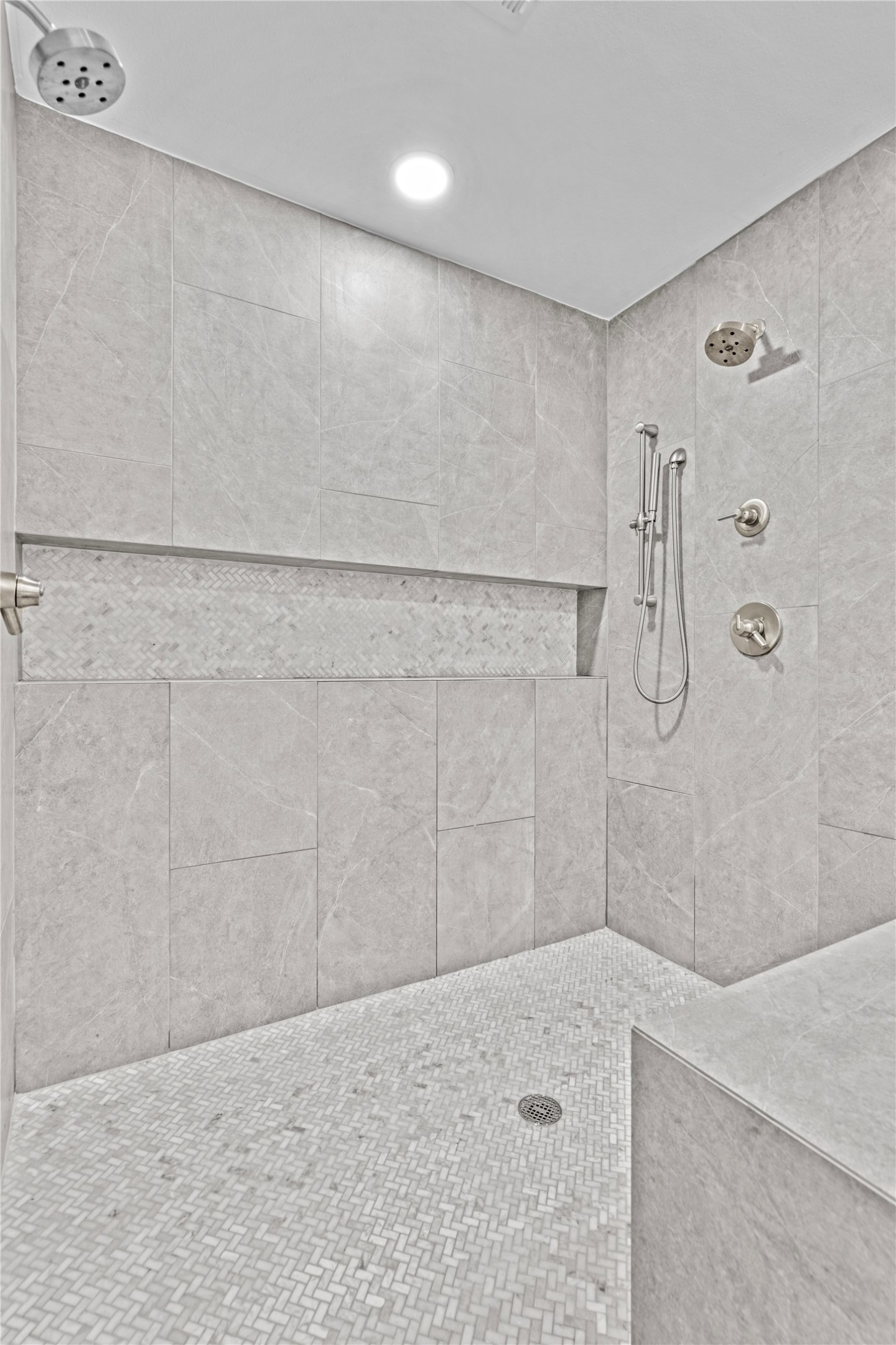 7107 Greenock Street Austin, TX 78749 - Photo 24 of 40 The shower features light-colored tile walls, a mosaic tile floor, and a built-in shower bench