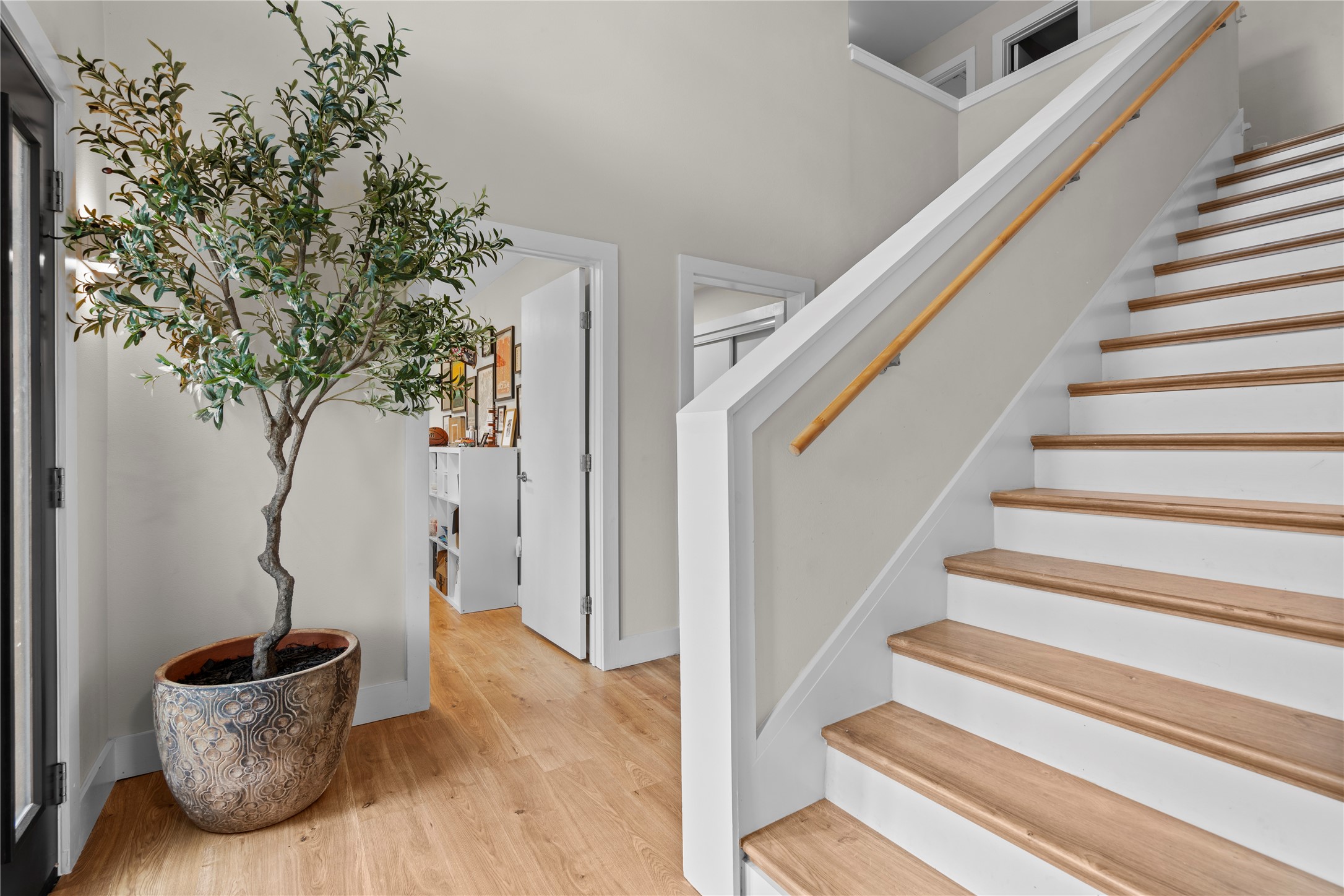 7107 Greenock Street Austin, TX 78749 - Photo 29 of 40 Entryway featuring hardwood floors and a white staircase with wooden treads and a wooden handrail