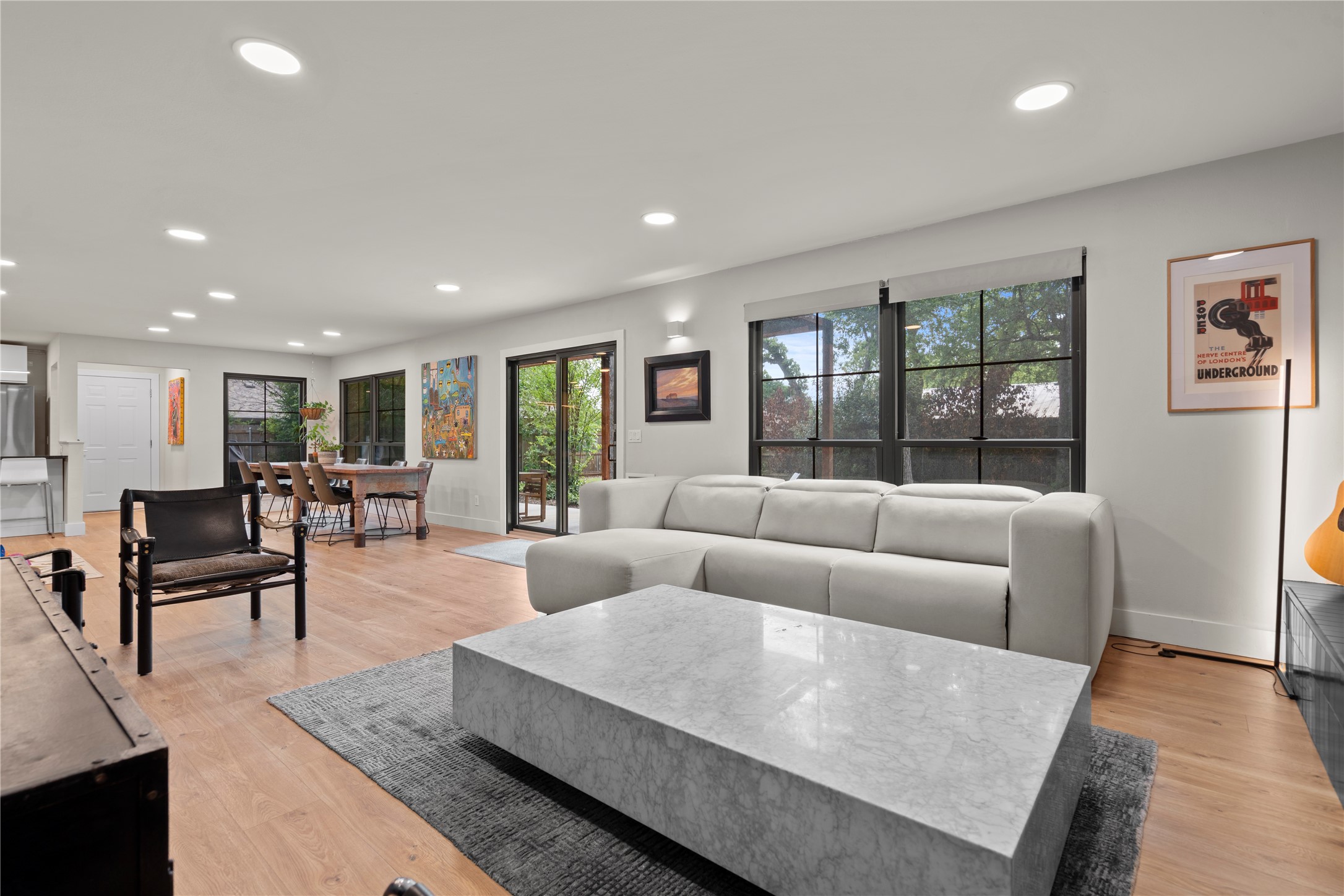 7107 Greenock Street Austin, TX 78749 - Photo 8 of 40 The property features an open-concept living area with light wood flooring, recessed lighting, and large windows that provide ample natural light