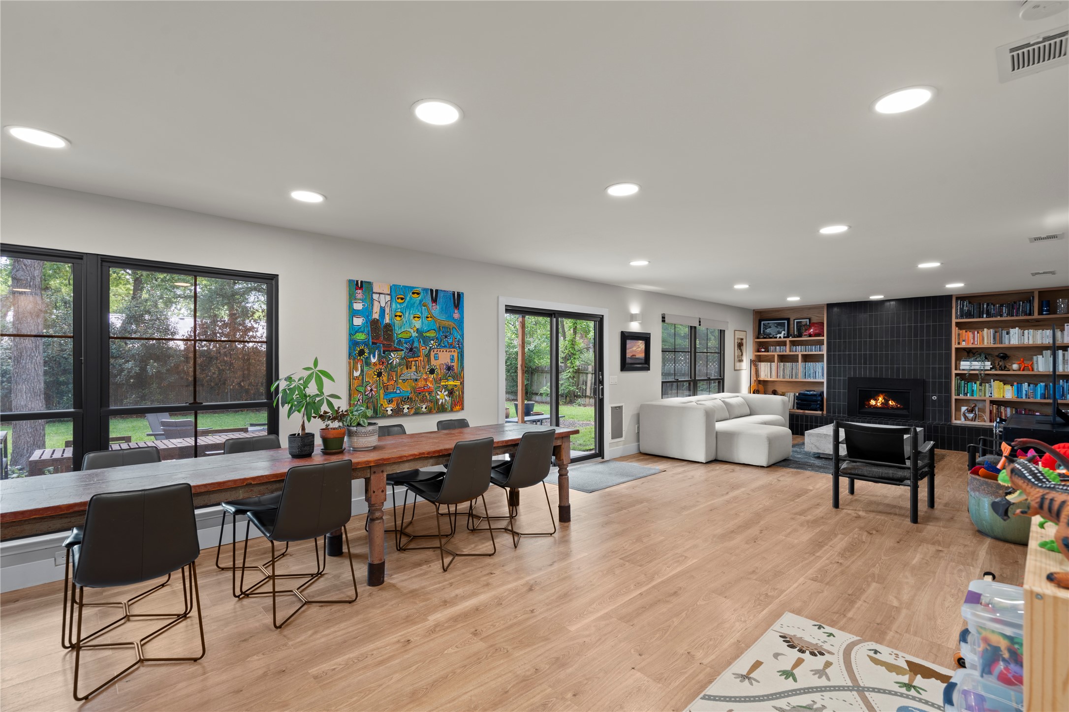 7107 Greenock Street Austin, TX 78749 - Photo 10 of 40 The expansive living area features light wood flooring, large windows overlooking the yard, and recessed lighting