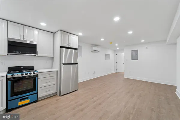 a kitchen with a refrigerator and a stove top oven