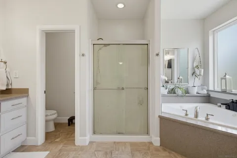 a bathroom with a granite countertop sink toilet and mirror