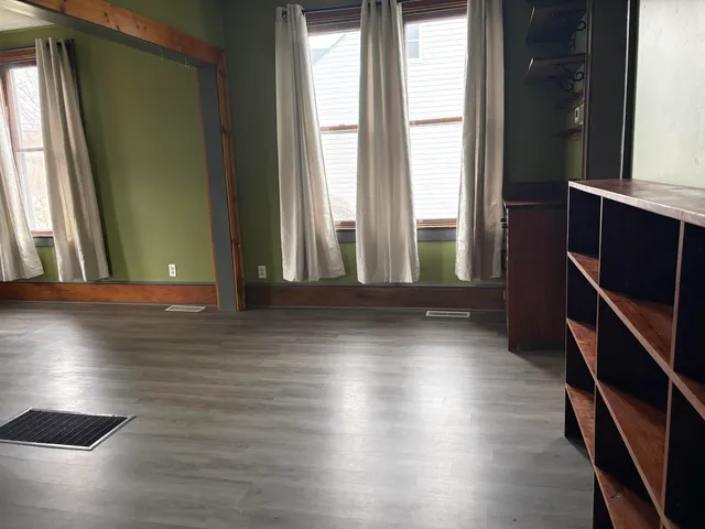 a view of a room with wooden floor and windows