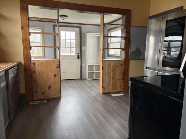 an empty room with wooden floor and windows