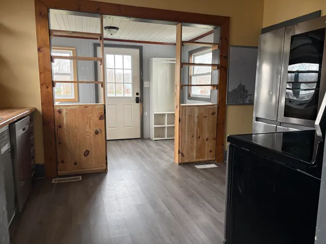 an empty room with wooden floor and windows