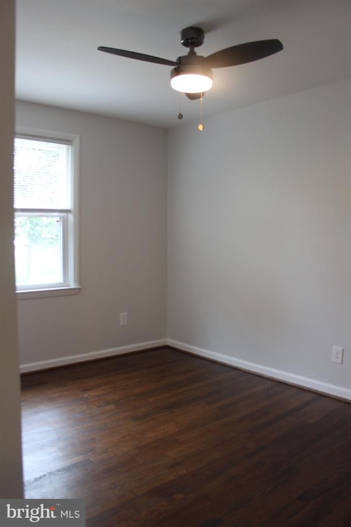 1654 Riverwood Road Baltimore, MD 21221 - Photo 16 of 30 a view of an empty room with wooden floor and a window