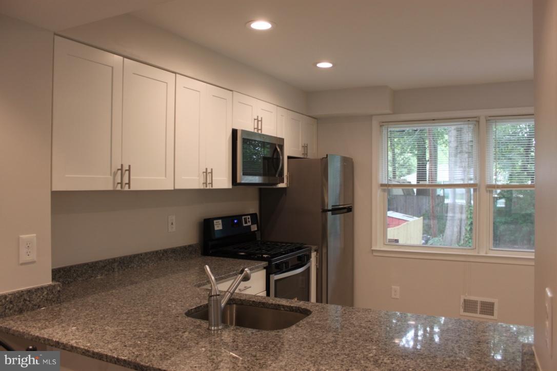 1654 Riverwood Road Baltimore, MD 21221 - Photo 6 of 30 a kitchen with stainless steel appliances granite countertop a refrigerator stove and microwave