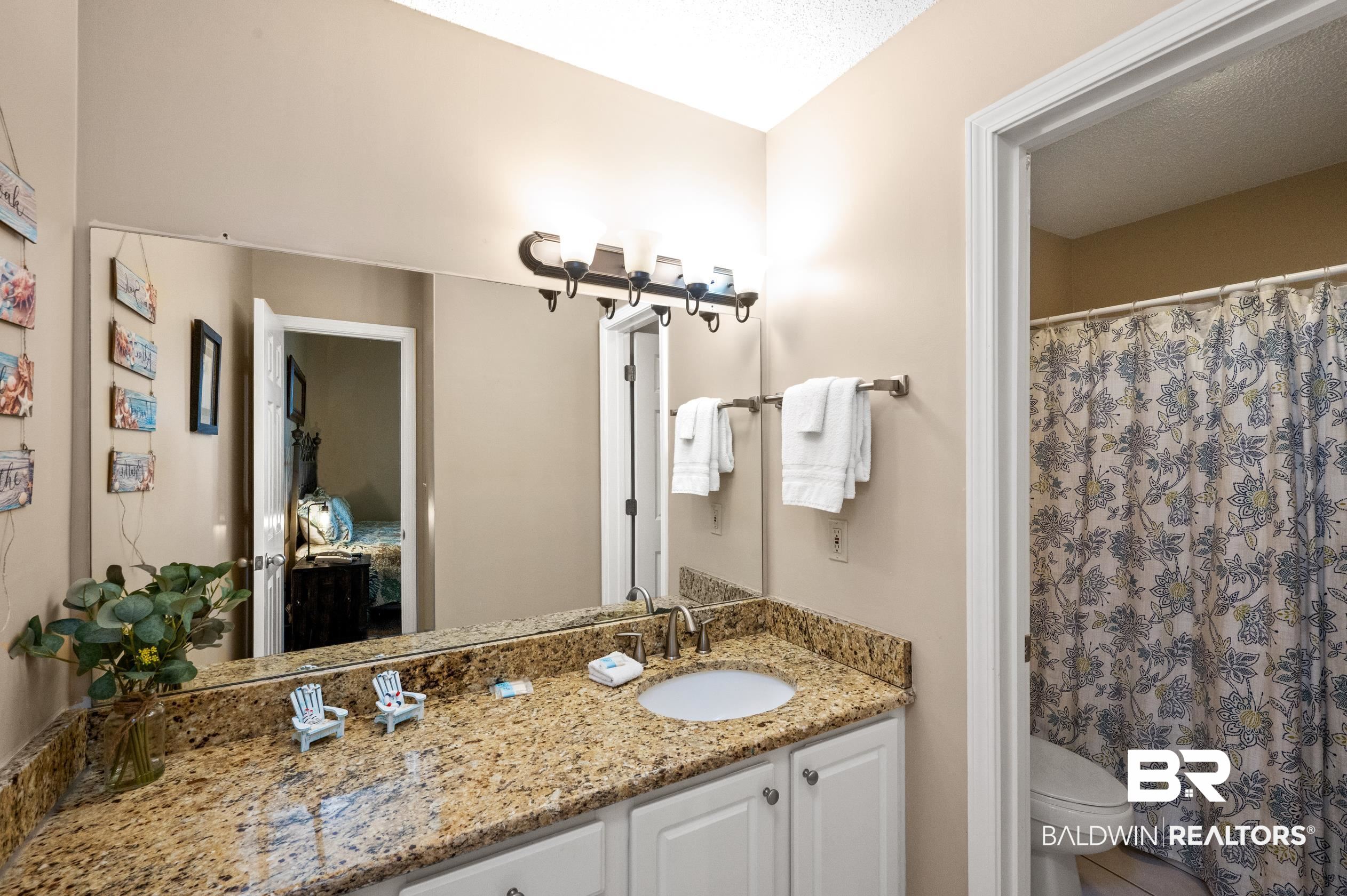1380 Fort Morgan Road, Unit 106 Gulf Shores, AL 36542 - Photo 11 of 20 Full bathroom with a shower with shower curtain, toilet, and vanity