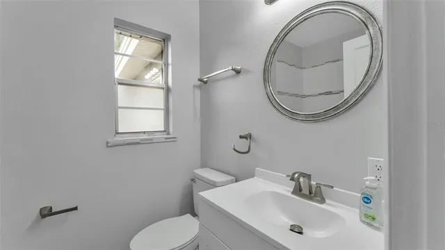 a bathroom with a toilet a sink and a mirror