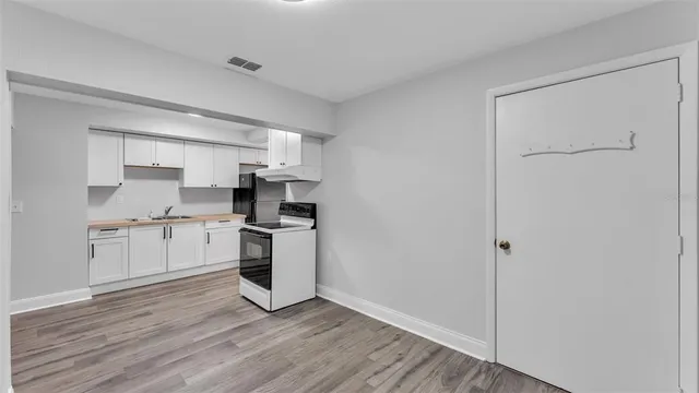 a kitchen with a refrigerator stove and white cabinets