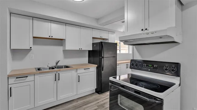 a kitchen with white cabinets and appliances