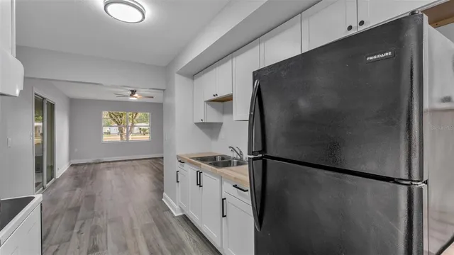 a kitchen with a refrigerator and a wooden floor