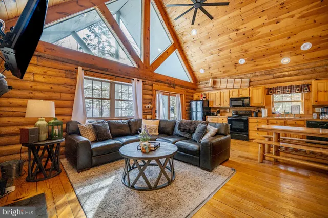 a living room with furniture and a dining table with wooden floor