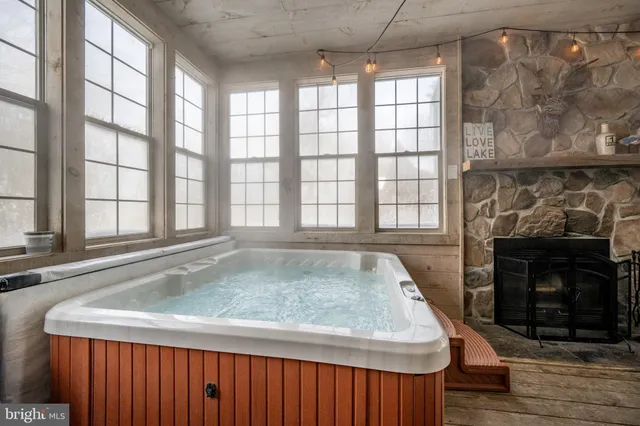 a living room with furniture a flat screen tv and floor to ceiling windows
