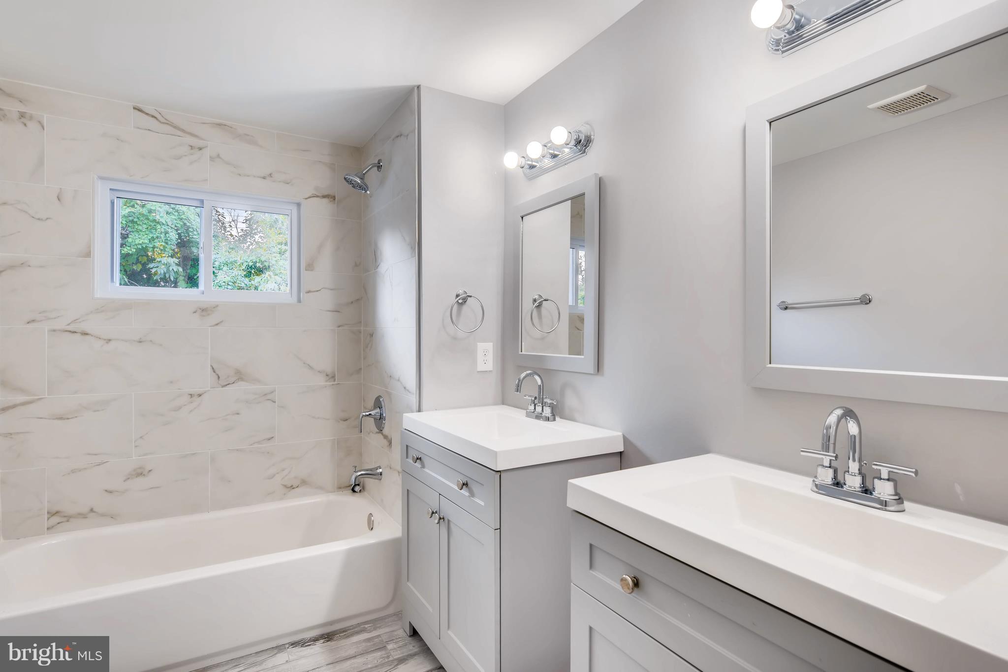 4103 Ronis Road Baltimore, MD 21208 - Photo 14 of 22 a bathroom with a sink a large mirror and a bathtub
