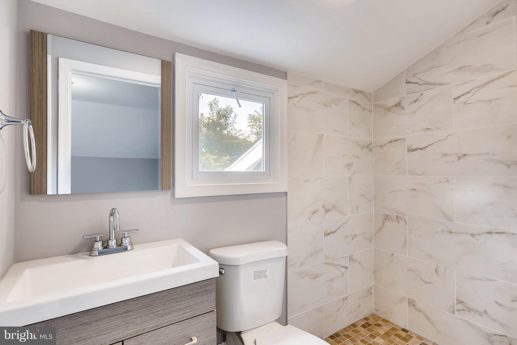 4103 Ronis Road Baltimore, MD 21208 - Photo 17 of 22 a bathroom with a sink a toilet and a mirror