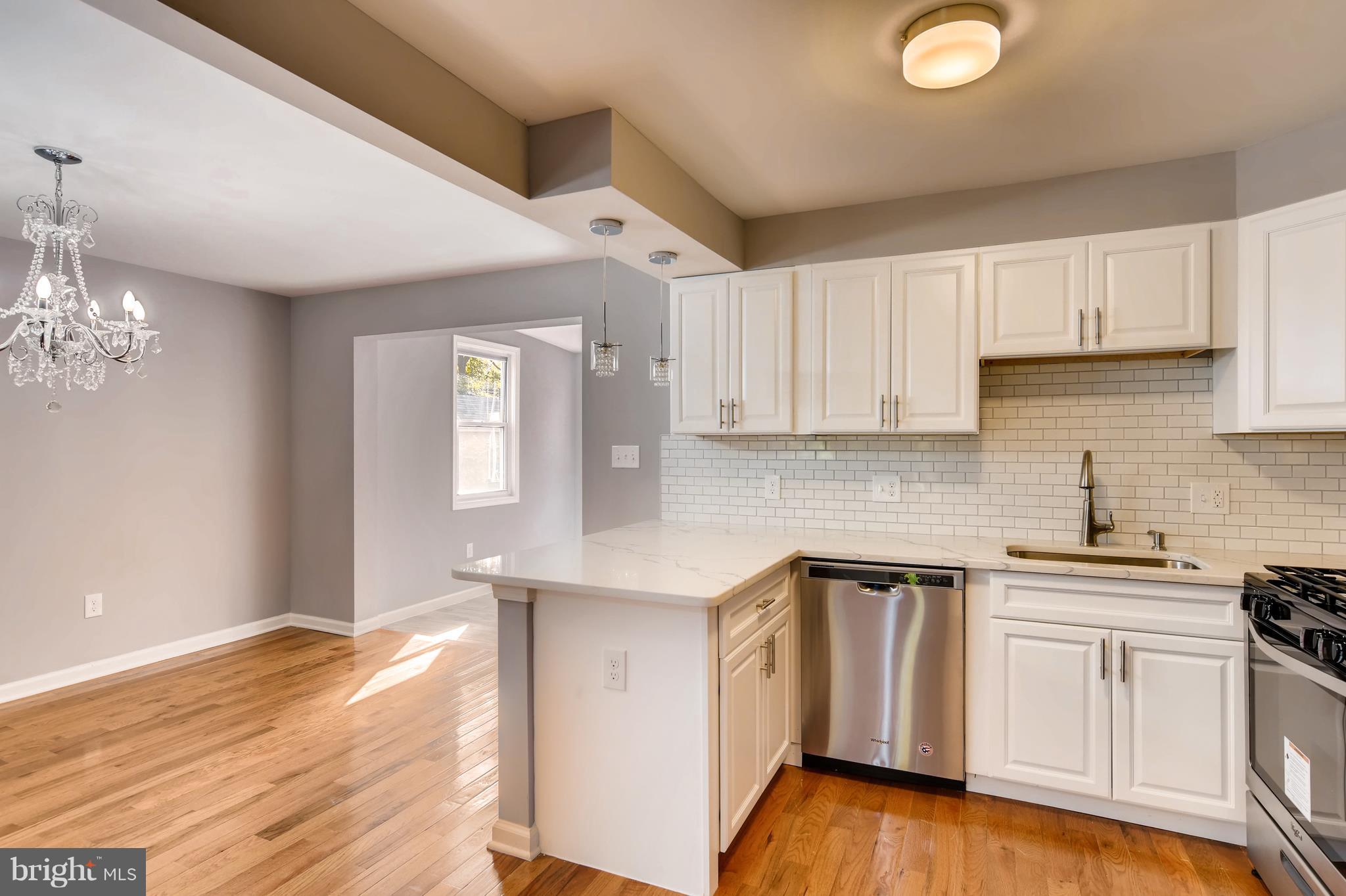 4103 Ronis Road Baltimore, MD 21208 - Photo 9 of 22 a kitchen with cabinets stainless steel appliances and wooden floor