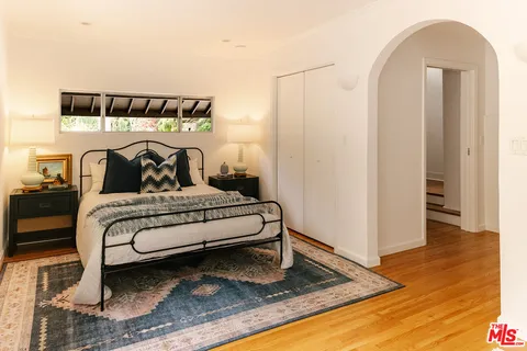 a bedroom with a bed and wooden floor