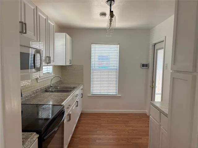 a kitchen with stainless steel appliances granite countertop a sink stove and cabinets