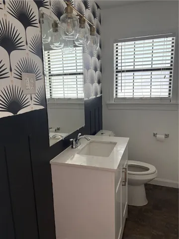 a bathroom with a sink toilet and window