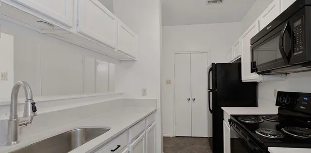a kitchen with stainless steel appliances a sink stove and refrigerator
