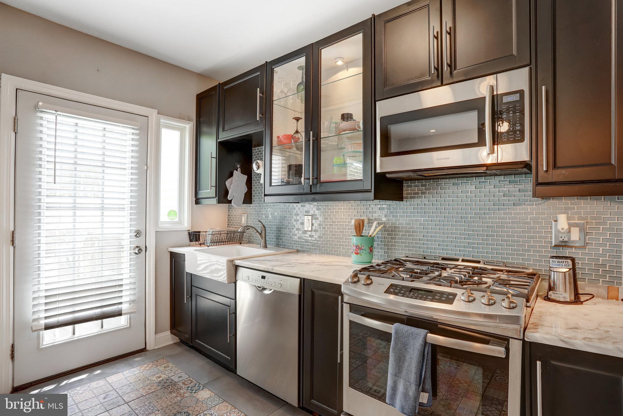 4627 12th Street Northeast Washington, DC 20017 - Photo 46 of 56 a kitchen with stainless steel appliances granite countertop white cabinets a stove top oven and a sink